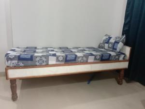 a bed with a blue and white quilt on it at Family Room in Indore