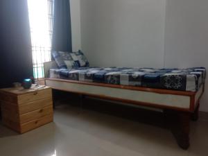 a bed sitting in a room with a night stand at Family Room in Indore