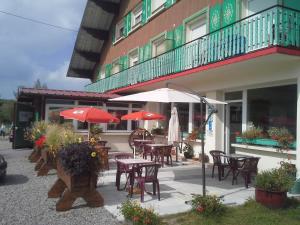an outdoor patio with tables and chairs and umbrellas at Chalet Résidence La Combeauté in Girmont-Val-dʼAjol +31 photos