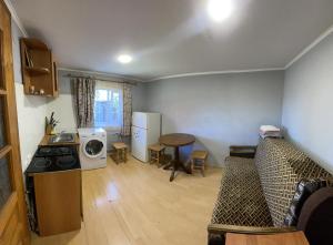 a kitchen and living room with a couch and a table at Mini Cottage in Yablunytsya