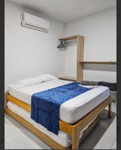 a bedroom with a bed with a blue blanket on it at Casa boquilla in Cartagena de Indias
