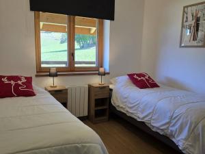 zwei Betten in einem Zimmer mit einem Fenster und zwei Lampen in der Unterkunft Appartement neuf 3 pièces, vue piste, parking couvert - FR-1-291-1026 in Valmorel