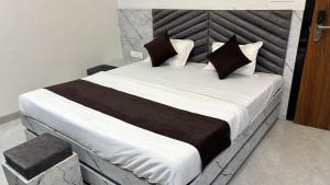 a bedroom with a large bed with black and white pillows at HOTEl SHREE ASHTVINAYAK GRAND in Mandlā