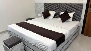 a large bed with black and white sheets and pillows at HOTEl SHREE ASHTVINAYAK GRAND in Mandlā