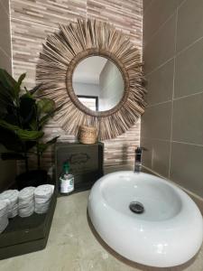 une salle de bain avec un lavabo, un miroir et des serviettes dans l'établissement Stunning Modern Apartment in heart of Agadir for families, à Agadir