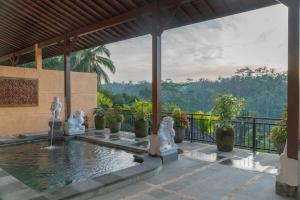 a pool with statues in front of a building at Grand Campuhan in Tegalalang