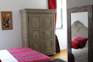 1 dormitorio con un gran armario marrón junto a una cama en Villa Toscane, en Marciac