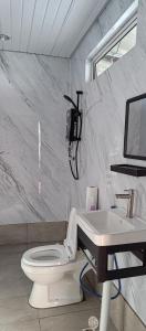 une salle de bain avec des toilettes blanches et un lavabo dans l'établissement Sea Plus Water Challet, à Semporna