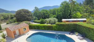 a garden with a swimming pool and a house at Le Mas du Grand Chêne - Chambres & Roulotte in Nyons