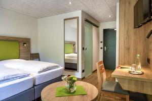 a hotel room with a bed and a table with flowers at Hotel-Gasthof Rangau in Ansbach