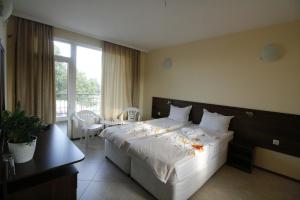 a hotel room with a large bed and a window at Hotel Marant in Sozopol