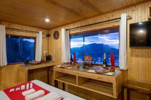 a room with a table and a window with a view at Syamantac Villa in Kodaikānāl