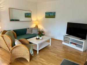 a living room with a couch and a tv at Haus Lykkelig in Zingst