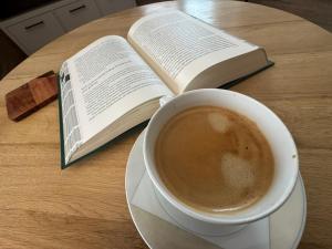 a cup of coffee and a book on a table at U Progu Rynku in Starogard Gdański