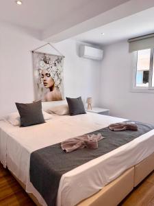 Un dormitorio con una gran cama blanca con un cuadro en la pared. en SeaBastian Suite, en Ayia Napa