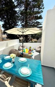 una mesa azul y sillas con sombrilla en el patio en SeaBastian Suite, en Ayia Napa