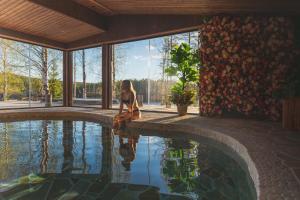 a woman sitting next to a swimming pool at Aito Igloo & Spa Resort in Rovaniemi