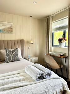 una camera da letto con un letto, una scrivania e una finestra di Spring view a Storrington Altre 2 foto