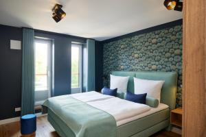 a bedroom with a large bed with blue walls at Pidder-Lyng Apartment 11 in Böhl
