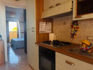 a kitchen with a sink and a stove top oven at Una Piscina sul Mare Apartment in Milazzo