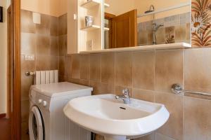 Un baño con lavabo, inodoro y espejo. en Casa Vacanza Lola, en Castiglion Fiorentino 16 fotos más