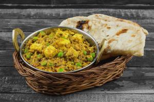 una ciotola di pollo e riso in un cestino con una fetta di pane di Super Hotel O Dakshin Dwar Formerly Radha Krishna Niwas a Puri