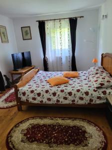 ein Schlafzimmer mit einem Bett mit geblümter Bettdecke in der Unterkunft Casa Nadia in Voineasa