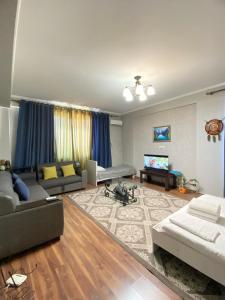 un grand salon avec un canapé et une télévision dans l'établissement Логвиненко 32, à Bishkek