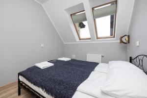a white bedroom with a bed with a blue blanket at Peaceful Apartment Wrzosowo Bay with Parking by Noclegi Renters in Wrzosowo +11 photos