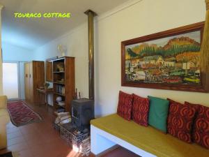a living room with a couch and a painting on the wall at Touraco in Hogsback