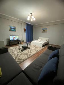 un salon avec un canapé et un lit dans l'établissement Логвиненко 32, à Bishkek