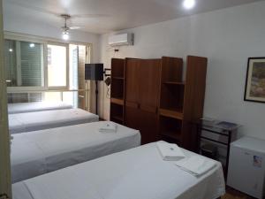 a room with two beds and a shelf and a window at Hotel Paraiso in Santa Maria +54 photos