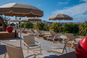 a group of chairs and umbrellas on a patio at Best Western Premier Le Patio des Artistes Wellness Jacuzzi in Cannes