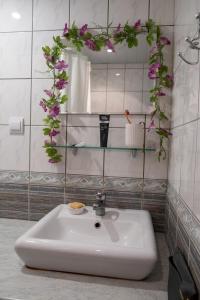 a bathroom with a sink with flowers on the wall at Ruumikas looduslik pärl- Self check-in in Viljandi +9 photos