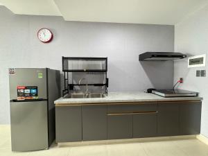 a kitchen with a sink and a clock on the wall at PAPAYA APARTMENT Căn hộ Sophia Center RACH GIA in Ấp Rạch Mẹo