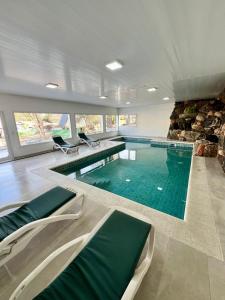 a large swimming pool with chairs in a building at Cabañas Alpendorf in Villa General Belgrano