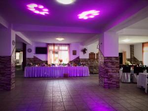 a banquet hall with purple lights on the ceiling at Vila Cretu Bran in Bran +48 photos