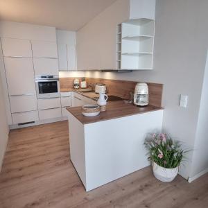 a kitchen with white cabinets and a counter top at Himmel & Meer Suite in Timmendorfer Strand