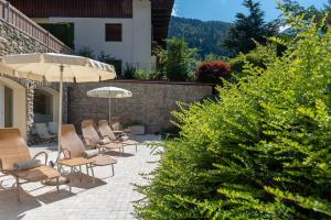 grupa krzeseł i parasol na tarasie w obiekcie Beverly Alps Hotel & Spa w mieście Pinzolo +34 zdjęcia