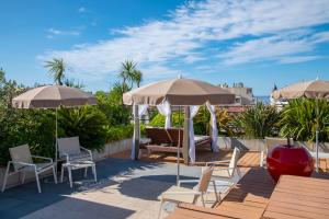 a patio with tables and chairs and umbrellas at Best Western Premier Le Patio des Artistes Wellness Jacuzzi in Cannes