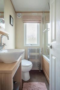 a bathroom with a sink and a toilet and a window at The Woodlark in Poole +16 photos