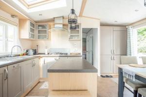 a kitchen with white cabinets and a island in it at The Woodlark in Poole