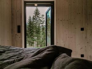 a bedroom with a bed and a large window at Tiny House Urlaub in Ybbsitz