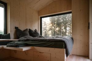 a bed in a room with a large window at Tiny House Urlaub in Ybbsitz