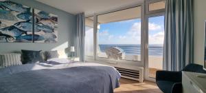 a bedroom with a bed and a view of the ocean at Himmel & Meer Suite in Timmendorfer Strand