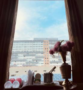 una ventana con un jarrón con flores sobre una mesa en Rk RESIDENCY, en Zirakpur