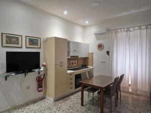 a kitchen with a table and a small kitchen with a television at A Ca da Nonnina in Carloforte +28 photos