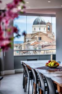 a dining room table with a view of a building at Attico vista mare con Jacuzzi - CASA LUXURY DIAMANTE in Ortona