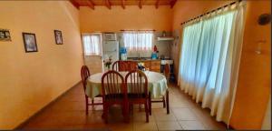 a dining room with a table and chairs and a kitchen at CASA EN VALLE GRANDE Country Club Solar Del Valle in San Rafael