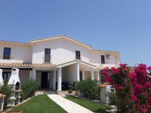 サンタンナ・アッレージにあるVilla Mirtoのピンクの花の庭のある大きな白い家